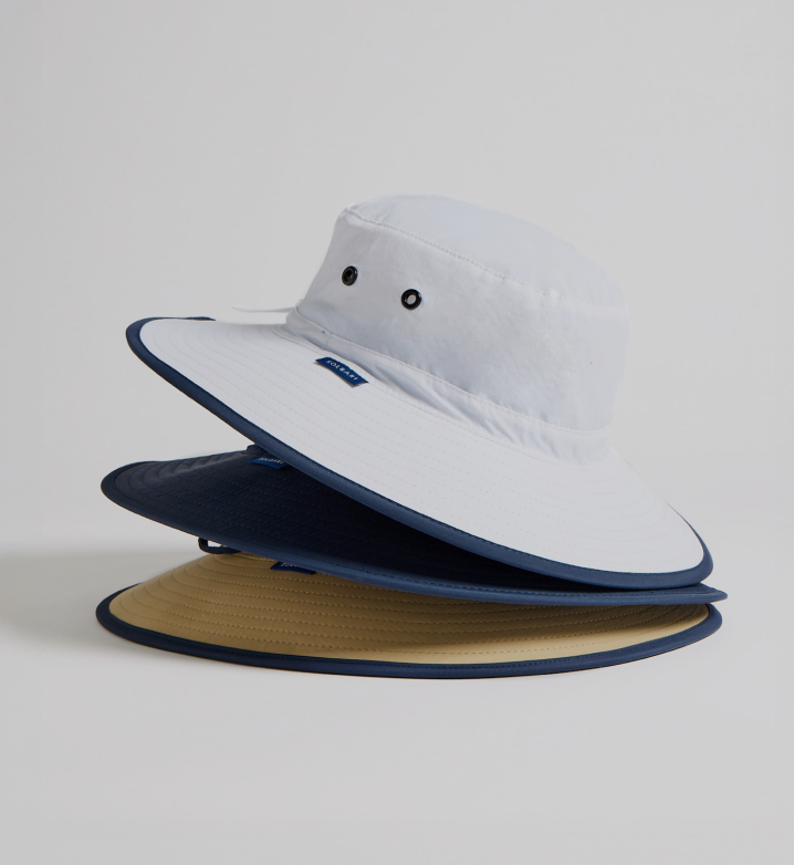 Three different colored bucket hats stacked on a light gray background